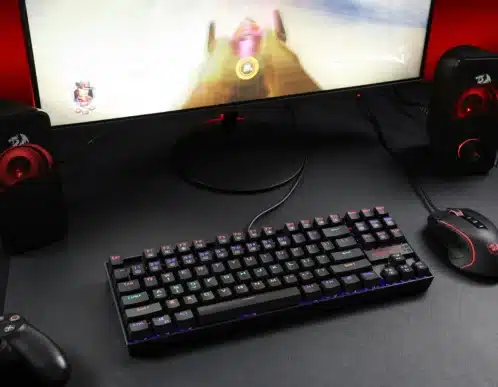 Teclado y monitor de un montaje gaming para PC, luces oscuras y ambiente de escritorio